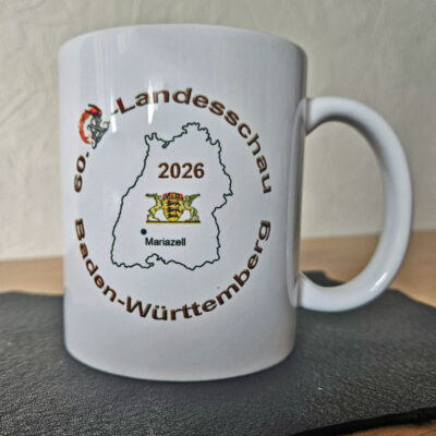 Tasse mit Logo der 60. AZ-Landesschau Baden-Württemberg 2026, Umrisskarte von Baden-Württemberg und markiertem Veranstaltungsort Mariazell.
